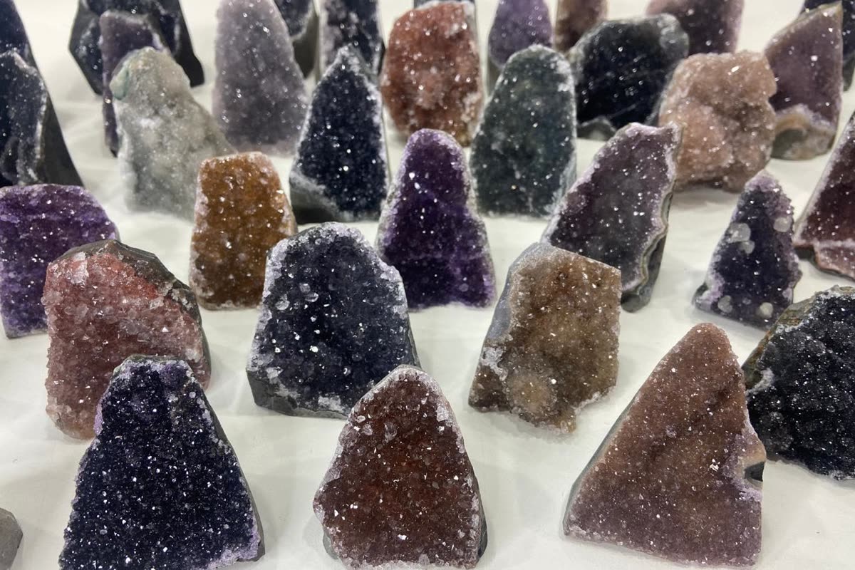 Many small Brazilian amethyst druzy pieces in rows: a typical wholesale lot of crystals sorted before shipping