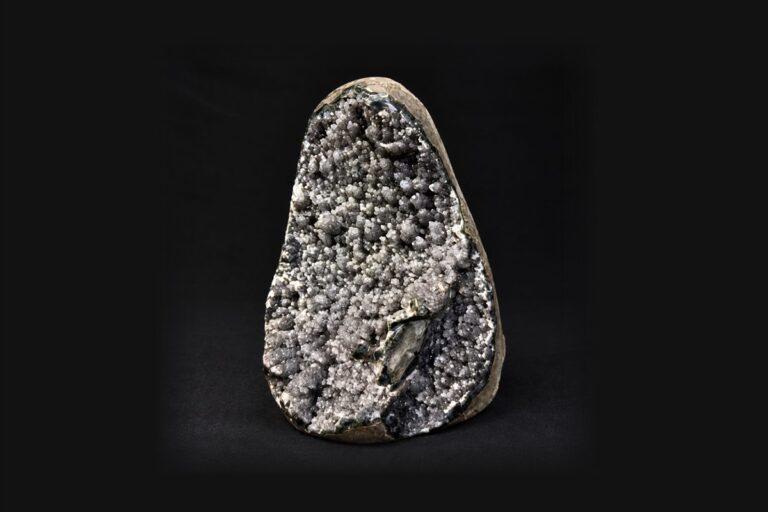 A sparkling grey druzy specimen on a black background