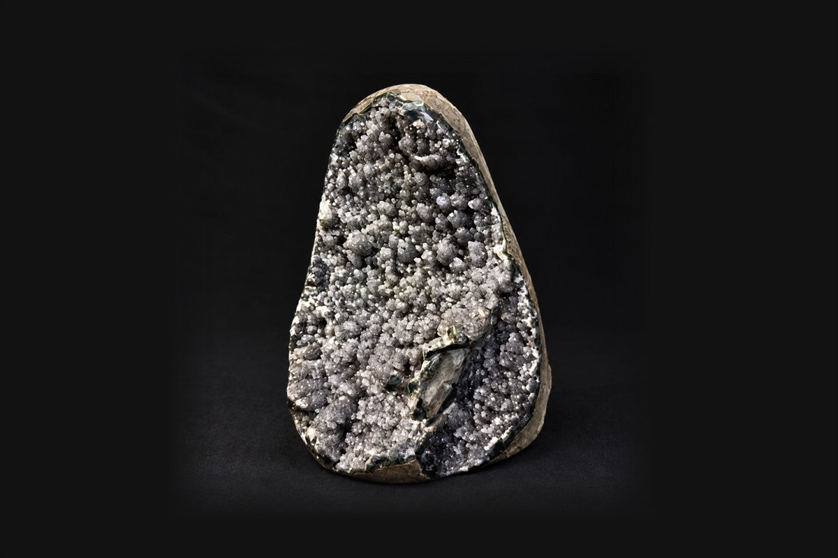 A sparkling grey druzy specimen on a black background