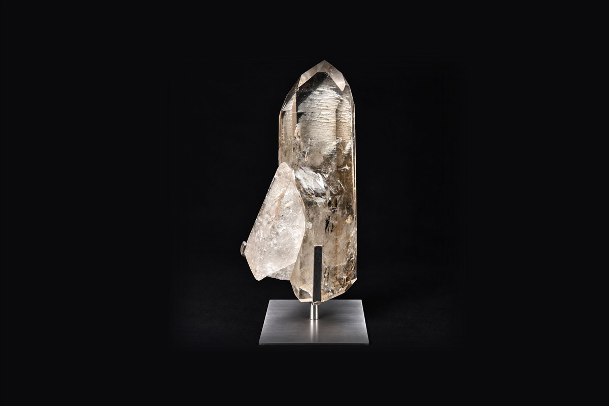 A smoky quartz point mounted on a brushed steel stand