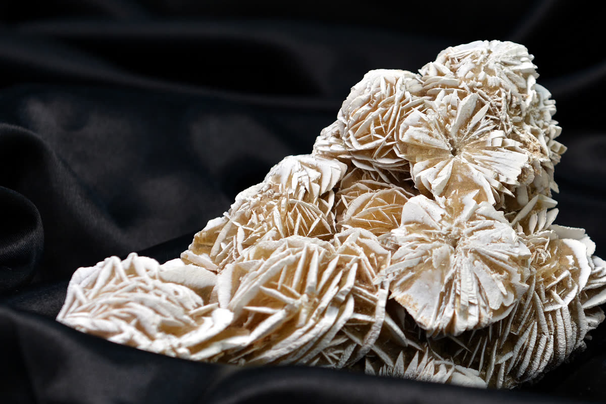 Desert rose crystal cluster on black fabric, an inexpensive stone worth little money compared with rare gem crystals