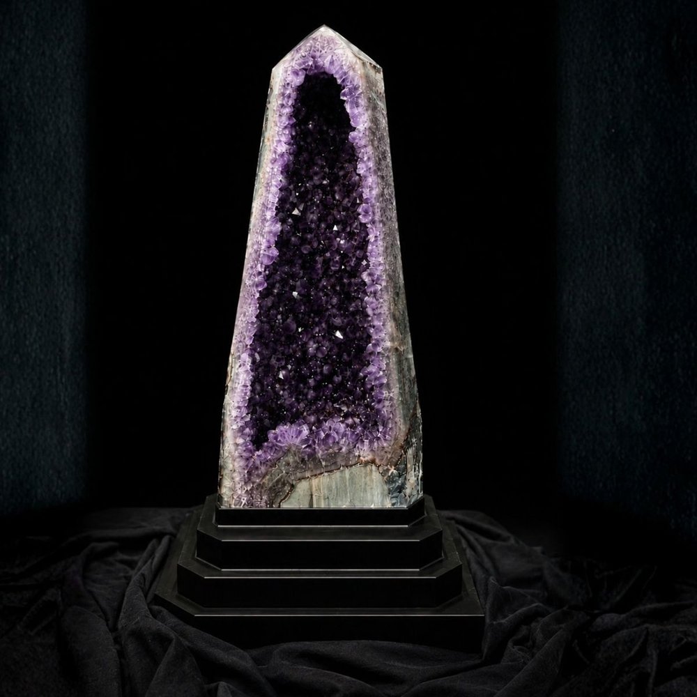 A tall Brazilian amethyst geode cathedral on a black stepped base