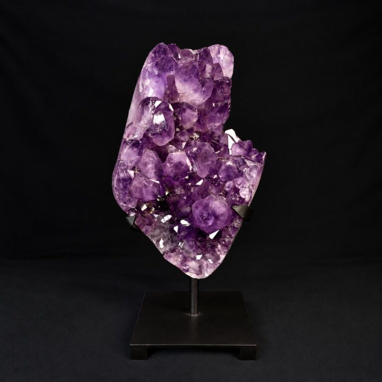 Purple amethyst crystal cluster on a black display stand