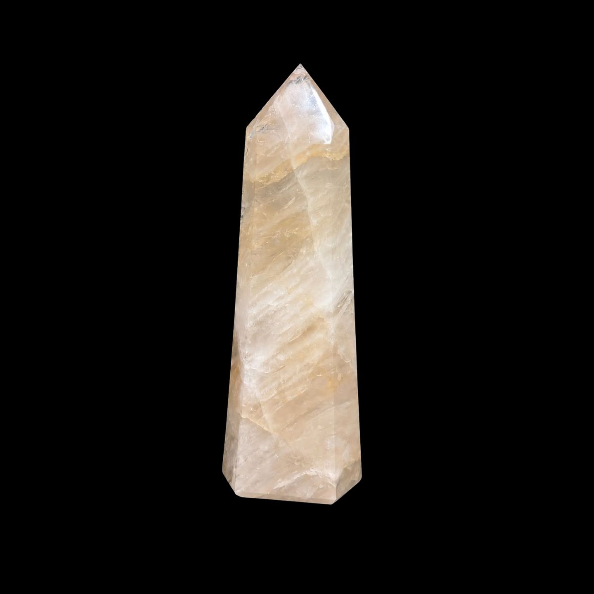 Polished quartz tower with pale golden veils, on a black background
