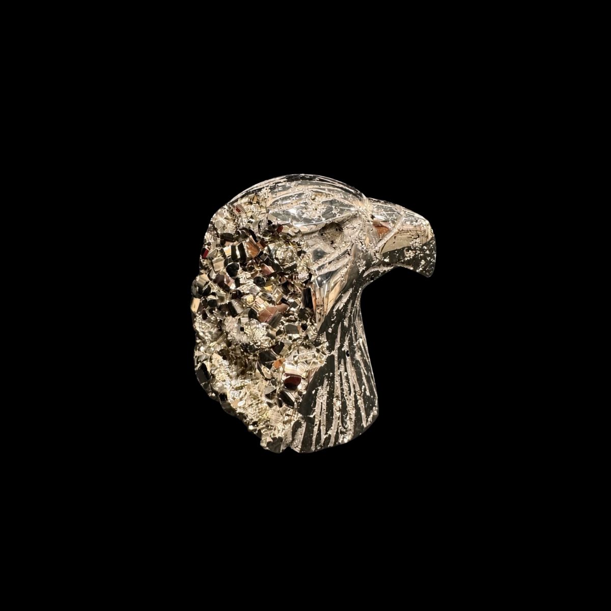 Polished pyrite carved into an eagle head, with natural pyrite crystals on the back